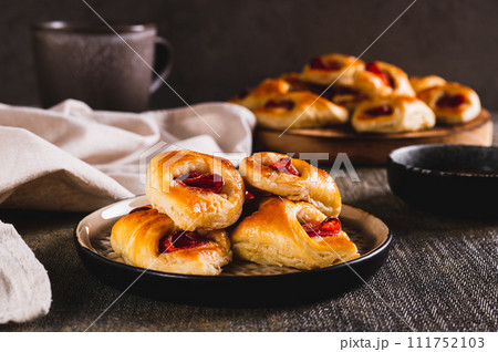 Appetizing envelopes with cheese and pepperoni sausage on a plate on the table 111752103