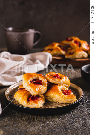Appetizing envelopes with cheese and pepperoni sausage on a plate on the table vertical view 111752106