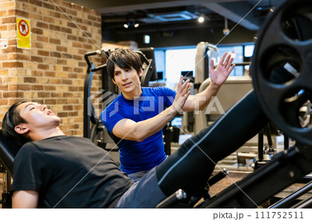 パーソナルトレーナーの指導を受ける若い男性 111752511