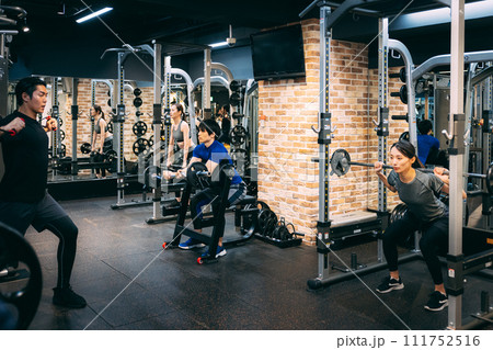フィットネスジムでトレーニングする男女 フィットネスジムでトレーニングする男女 111752516