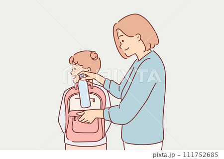 Mom puts bottle of water in daughter school backpack, taking care of child leaving for walk or study 111752685