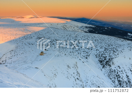 Winter, sunrise time, view from Snezka to Silesian house, krkonose mountains. Snezka is mountain on the border between Czech Republic and Poland. Winter, sunrise time, view from Snezka to Silesian house, krkonose mountains. Snezka is mountain on the border between Czech Republic and Poland. 111752872