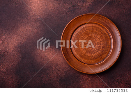 Empty ceramic round plate on dark textured concrete background Empty ceramic round plate on dark textured concrete background 111753558