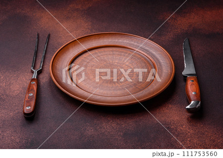 Empty ceramic round plate on dark textured concrete background 111753560