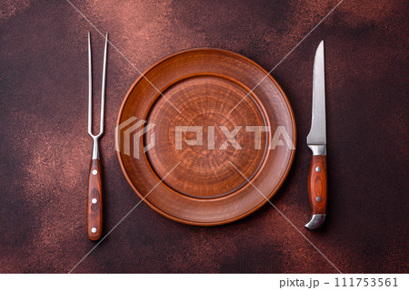 Empty ceramic round plate on dark textured concrete background 111753561
