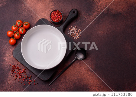 Empty ceramic round plate on dark textured concrete background Empty ceramic round plate on dark textured concrete background 111753580