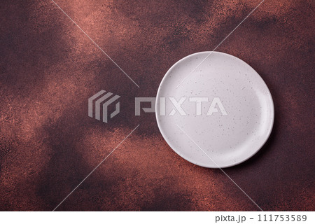 Empty ceramic round plate on dark textured concrete background 111753589