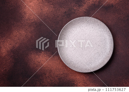 Empty ceramic round plate on dark textured concrete background 111753627