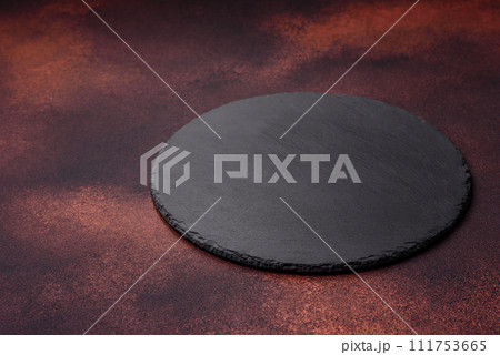 Empty ceramic round plate on dark textured concrete background 111753665