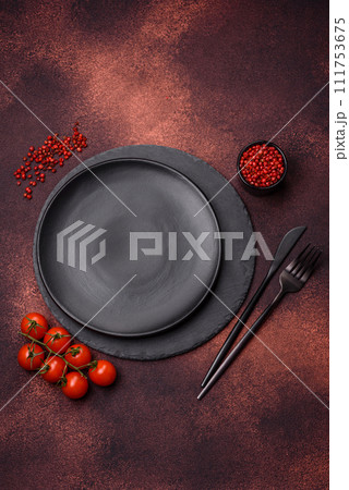 Empty ceramic round plate on dark textured concrete background 111753675
