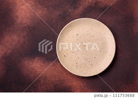 Empty ceramic round plate on dark textured concrete background 111753688