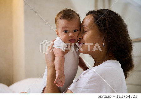 Delightful mother enjoys happy moments with her baby boy, cuddling him. Love. Tenderness. Happy Mother's Day concept 111754523