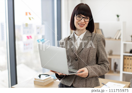Woman in formal wear managing successful company from modern workplace. Woman in formal wear managing successful company from modern workplace. 111755975