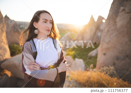 girl hiker in poncho on top of mountain at sunset girl hiker in poncho on top of mountain at sunset 111756377