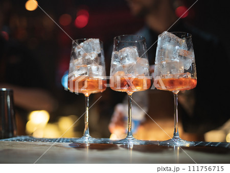 the bartender prepares a beautiful alcoholic cocktail at the bar counter the bartender prepares a beautiful alcoholic cocktail at the bar counter 111756715