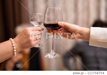 clinking glasses with alcoholic drinks in their hands 111756754