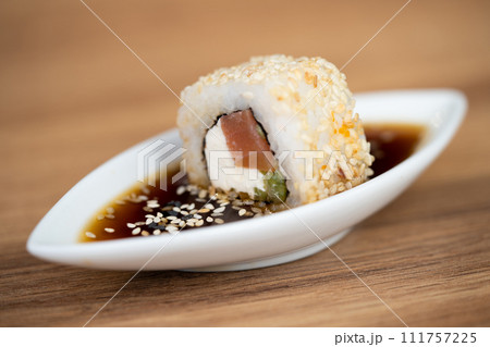 delicious traditional Japanese sushi and rolls on a plate in soy sauce delicious traditional Japanese sushi and rolls on a plate in soy sauce 111757225