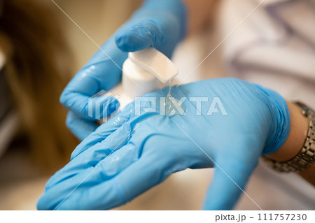 applying and rubbing the cosmetic product from the bottle into the hand applying and rubbing the cosmetic product from the bottle into the hand 111757230