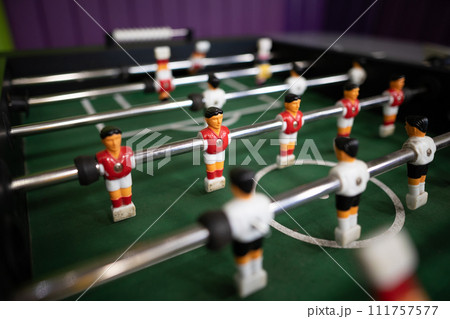 A close-up of the table football game of football figures on the field A close-up of the table football game of football figures on the field 111757577
