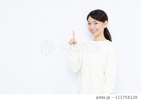 人差し指を立てる40代の女性 人差し指を立てる40代の女性 111758120