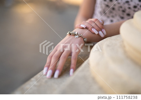 close-up of a girl's hand with a beautiful manicure and a jewelry bracelet on her hand 111758238
