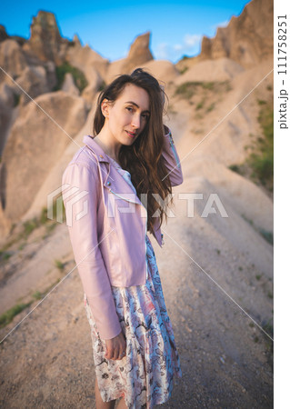 a beautiful girl walks on the top of the mountain enjoying the view 111758251