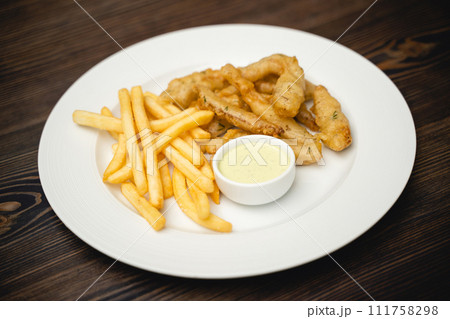 menu with fried shrimp and french fries with sauce on a plate. 111758298