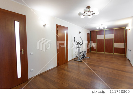 a spacious corridor in the house with doors to the rooms. a spacious corridor in the house with doors to the rooms. 111758800