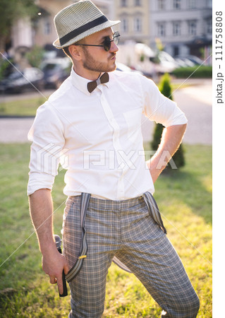 handsome presenter and showman in a stylish suit and hat with a microphone poses with the best emotions and acrobatic tricks handsome presenter and showman in a stylish suit and hat with a microphone poses with the best emotions and acrobatic tricks 111758808