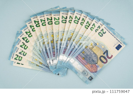many 20 euro bills on a blue background 111759047