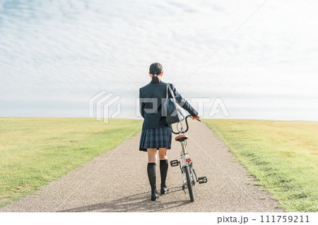 自転車で通学・登校・下校する制服姿の中学生・高校生（夢・希望・進路・道・将来・未来・青春・歩く） 111759211