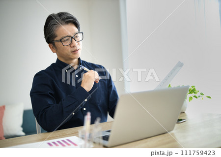 リビングでテレワークをするミドル男性 111759423
