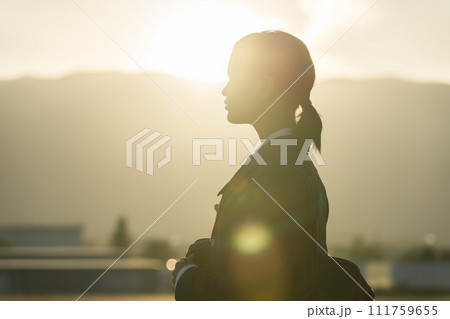 夕方に夕日の中を歩く高校生・中学生・女子高生（青春・思春期・悩み・いじめ） 111759655