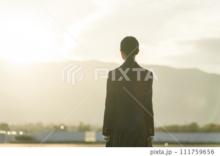 夕方に夕日の中を歩く高校生・中学生・女子高生（青春・思春期・悩み・いじめ） 111759656