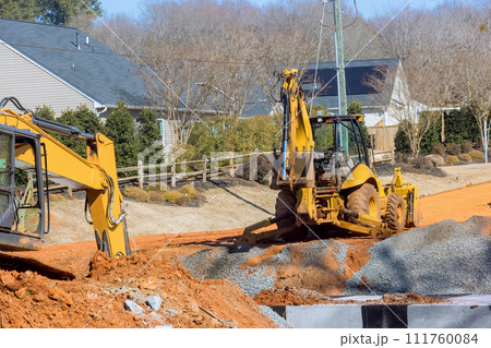 During earthmoving operations to prepare an infrastructure area, an excavator digs trenches During earthmoving operations to prepare an infrastructure area, an excavator digs trenches 111760084