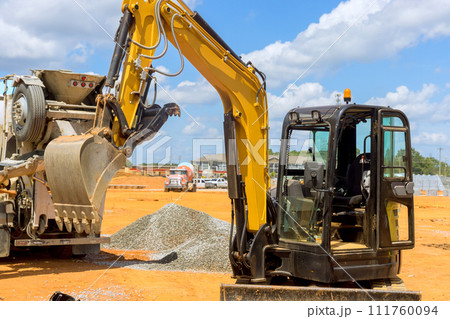 Excavator working on an industrial site under infrastructure development Excavator working on an industrial site under infrastructure development 111760094