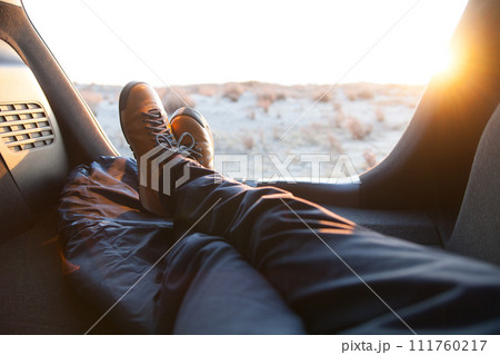 車中泊、車の後部座席から夕日を眺める 111760217
