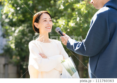 街頭インタビューを受ける主婦 111760363