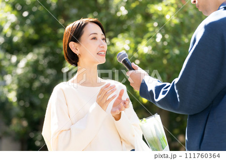 街頭インタビューを受ける主婦 111760364