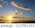 夕日に染まる冬の空と海中電柱 111761143