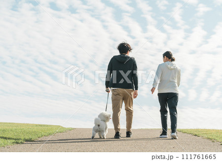 公園で犬の散歩をする家族・夫婦・カップル・男女の後ろ姿 111761665