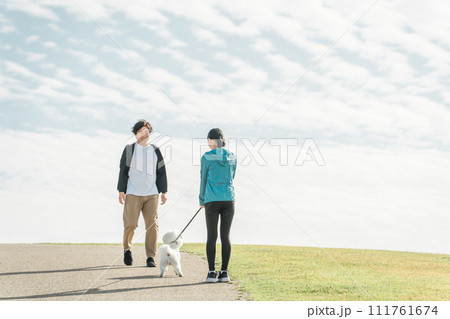 公園で犬の散歩をする家族・夫婦・カップル・男女 公園で犬の散歩をする家族・夫婦・カップル・男女 111761674