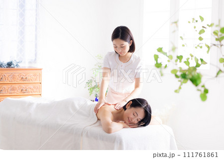 マッサージを受けるミドル女性とエステティシャン 111761861