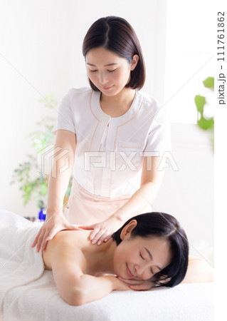 マッサージを受けるミドル女性とエステティシャン 111761862