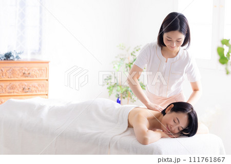 マッサージを受けるミドル女性とエステティシャン 111761867