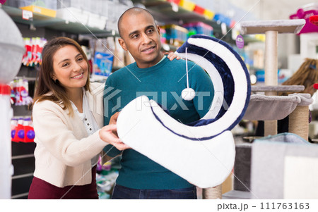 Couple choosing cat furniture supplies in shop Couple choosing cat furniture supplies in shop 111763163