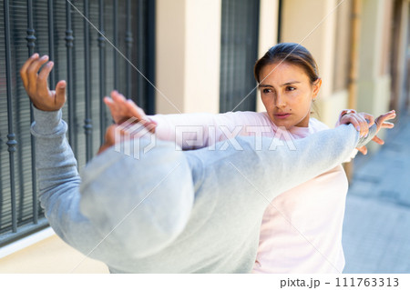 Young Latina using Krav Maga techniques to protect herself from attacker Young Latina using Krav Maga techniques to protect herself from attacker 111763313