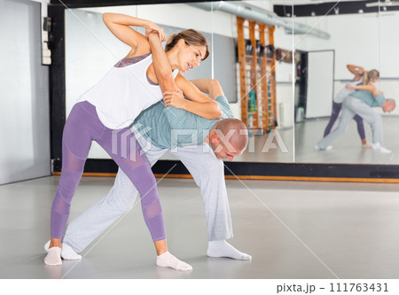 Active girl conducts painful grip on self-defense training in gym 111763431