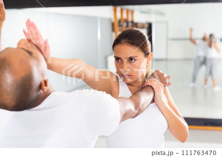 Active woman with professional trainer are training captures on the self-defense course in gym Active woman with professional trainer are training captures on the self-defense course in gym 111763470