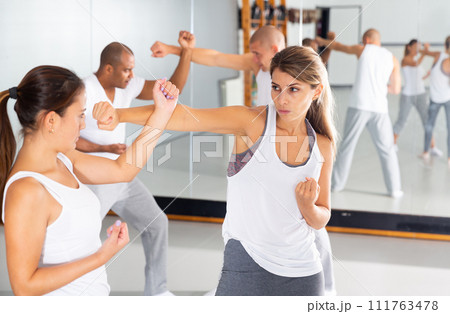 Young woman practicing self defence techniques with female partner 111763478